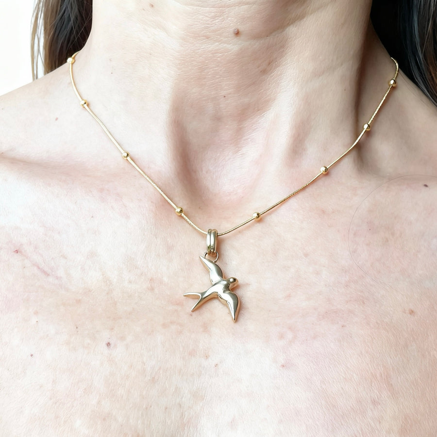 pendente rondine indossato colo oro